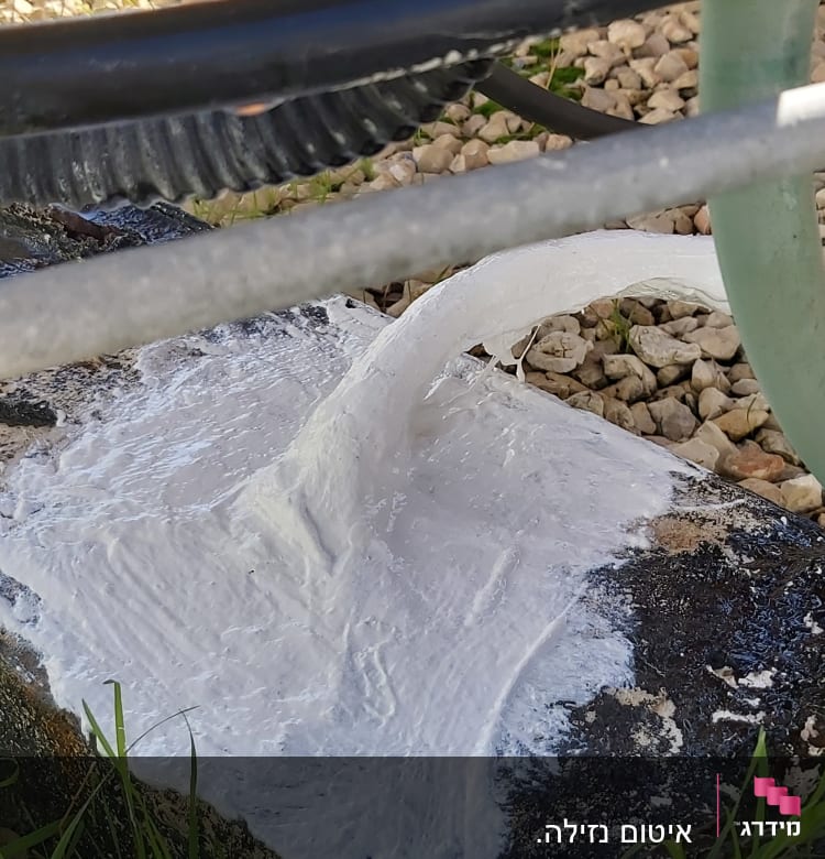 חומר איטום לבן על צינור מתכת ירוק